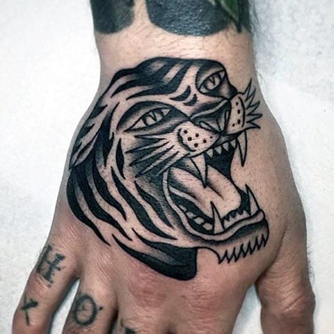 Tatuaż przedstawiający szczerzącego się tygrysa na ręce