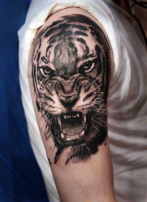 Tatuaż przedstawiający uśmiechniętego tygrysa na ramieniu