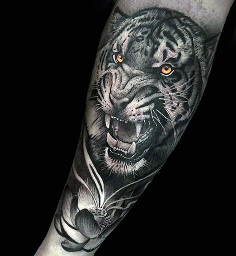 Tattoo van een grijnzende tijger op zijn arm