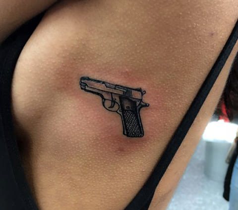 Pistola de tatuagem do lado da rapariga
