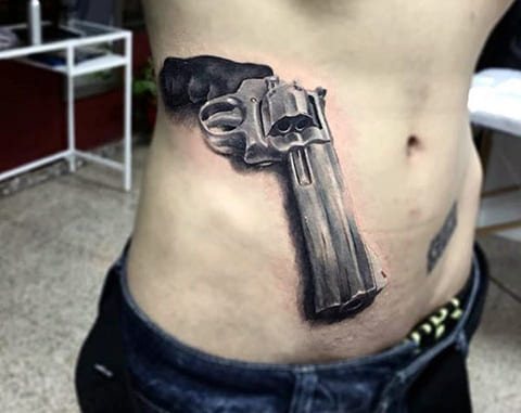 Татуиране на пистолет на страната на мъжа