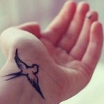 Tatuagem de um pássaro no pulso