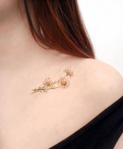 Tatuagem de margarida na clavícula de uma rapariga