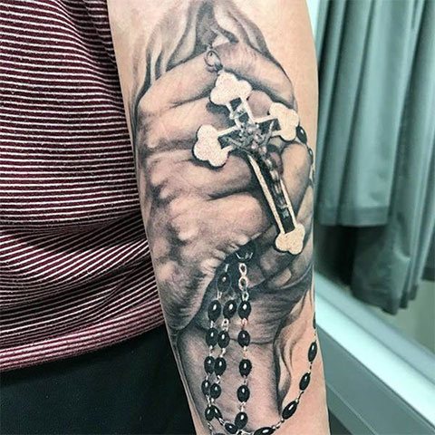 Татуировка на молеща се ръка с кръст