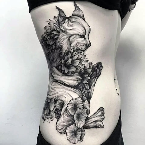 Tetoválás hiúz egy lány oldalán