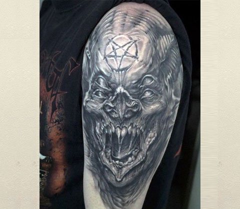 Tattoo van een demon op zijn schouder