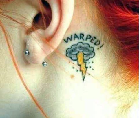 Tatoeage met een bliksemschicht op de hals achter het oor
