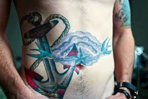 Anker tattoo op mannelijke buik - foto