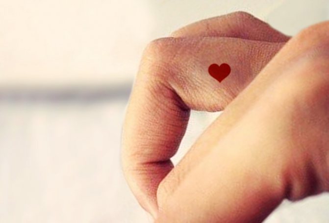 Sydän tatuointi sormeen. Merkitys, mitä se tarkoittaa, luonnoksia, valokuvia