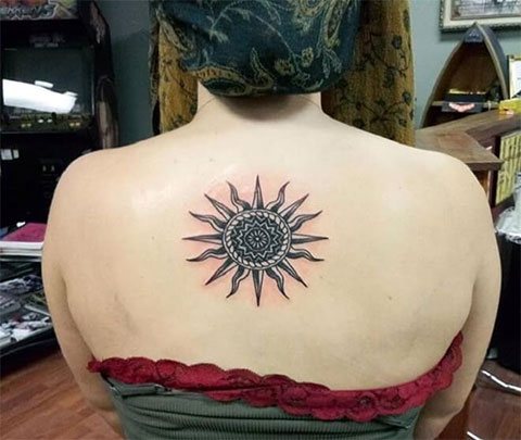 在女孩的背上纹上太阳的图案