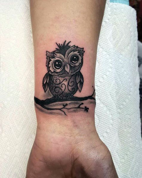 Tatuagem de uma coruja no seu pulso