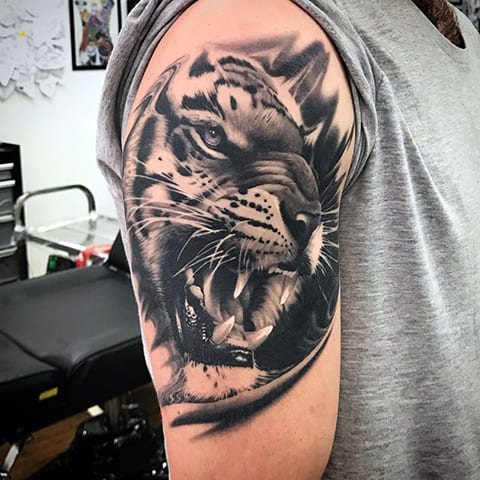 Tattoo van een tijger op zijn schouder