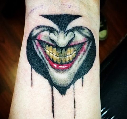 Tattoo Joker glimlach op zijn arm. Schetsen, foto