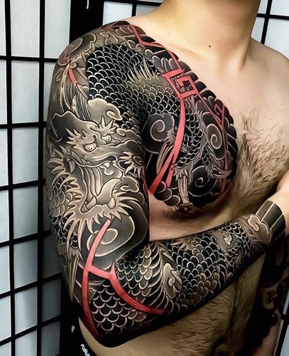 Japoniško stiliaus tatuiruotė. Piešiniai ant rankos, rankovės, kojos, nugaros: drakonas, karpis, tigras, gyvatė, žuvis, samurajus, gėlės, lapė, kaukė, feniksas. Nuotrauka