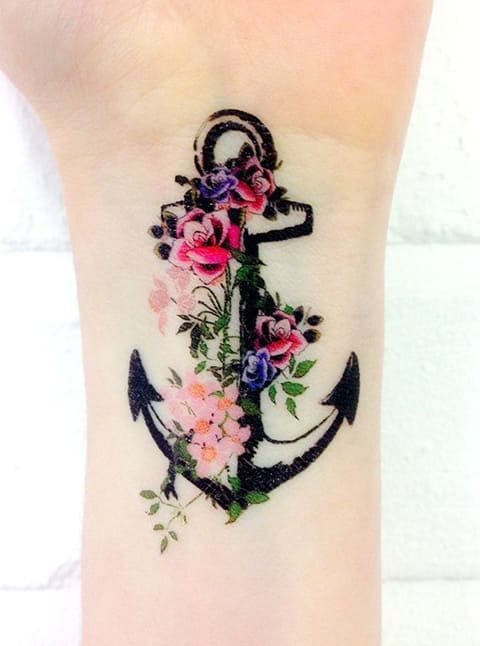 Tatuaj de ancoră cu flori pe încheietura mâinii unei fete - fotografie