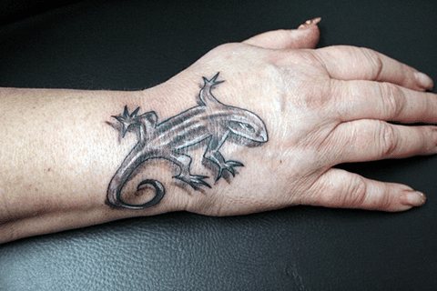Tetovált gyík a kezén