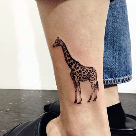Τατουάζ καμηλοπάρδαλη στο πόδι του - φωτογραφία