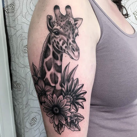 Tatoeage giraffe op de schouder van het meisje