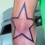 Estrela tatuada no cotovelo