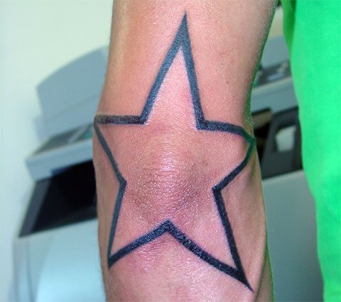 Tatuagem de estrela no cotovelo