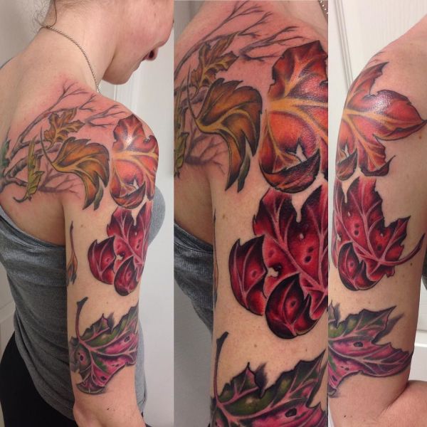 Tetovanie červených a oranžových listov na dievčenskom ramene