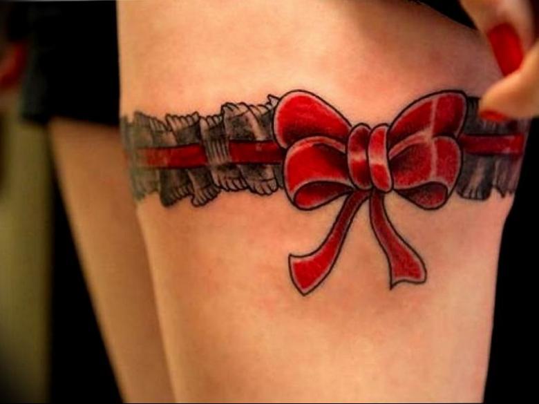 Tetovanie červenou mašľou v tvare podväzku