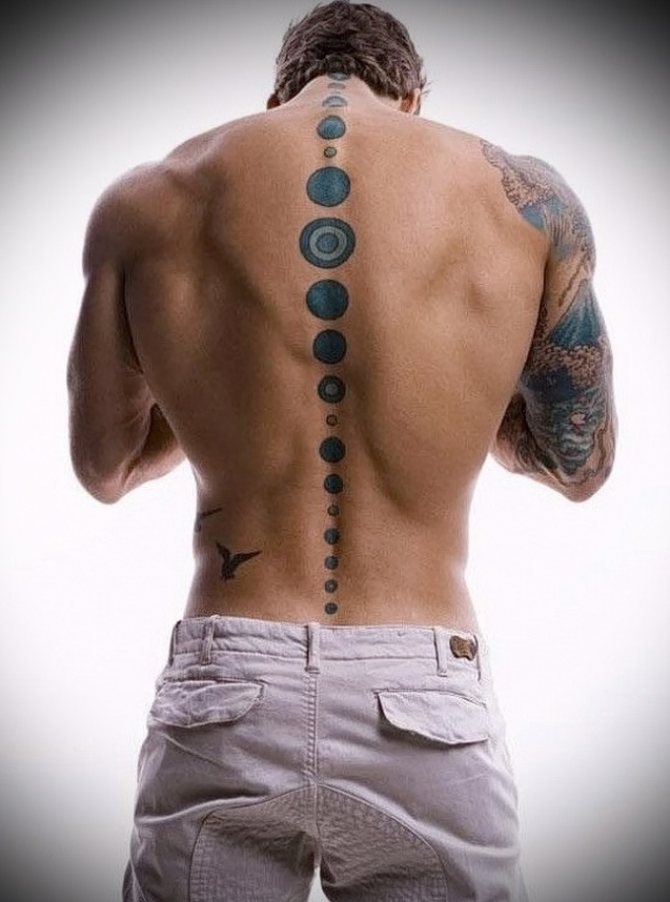 Tattoo-cirkels op mannelijke ruggengraat