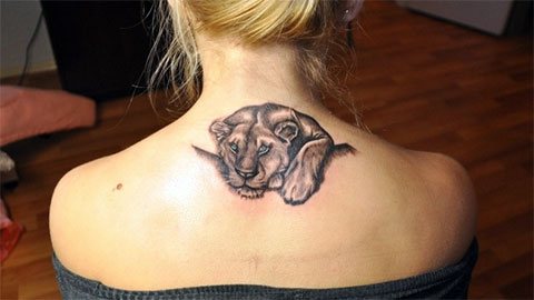 Tatovering af en løve på en piges ryg