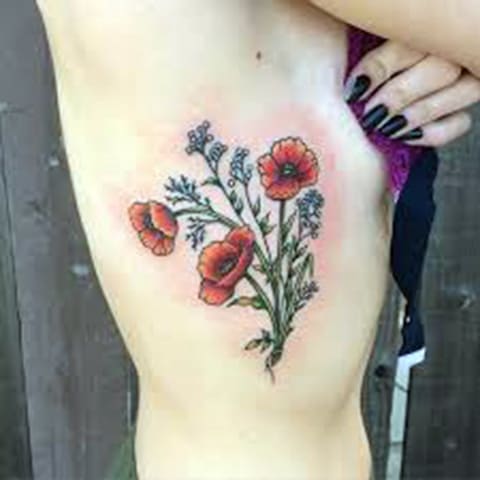 Tätowierung von Mohnblumen auf der Seite eines Mädchens - Foto