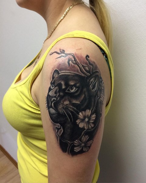 Pantteri tatuointi kukkien kanssa naisen olkapäässä