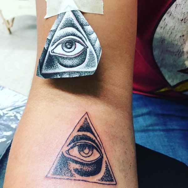 Piramide e montagna di tatuaggio dell'occhio sul polso