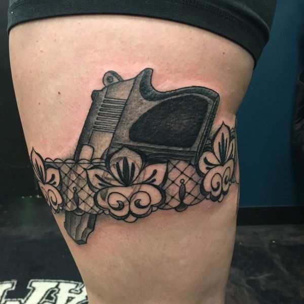 Tatuagem de cinto de ligas com pistola