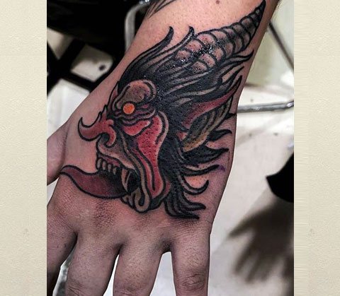 Demone cinese tatuato sulla mano