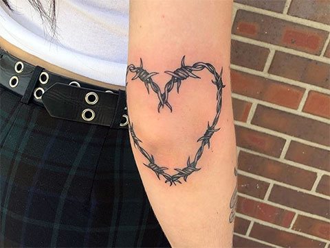 Szögesdrót szív tetoválás egy lányról