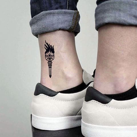 Tatuaggio di una piccola torcia sulla gamba