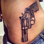 Татуировка на пистолет на страната на момиче