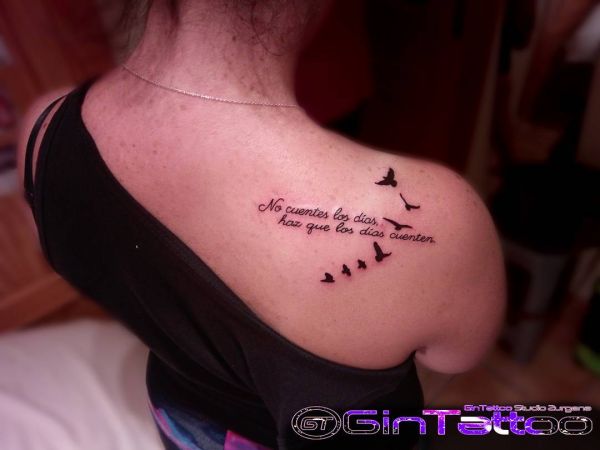 Tatuagem de um bando de aves no ombro de uma rapariga