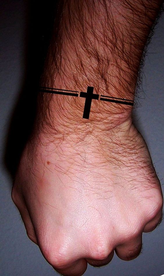 Tatuagem de uma cruz numa bracelete