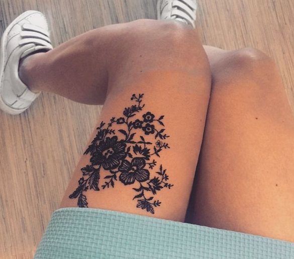 Tatouage de dentelle avec des tourbillons sur la jambe d'une fille