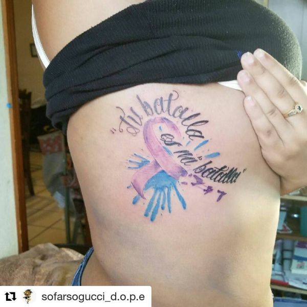 Tatuointi nauhan ja vesivärityyppisen kirjoituksen muodossa tytön vartalon sivulla.