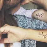 Tatoeages op twee armen voor meisjes, mannelijk op de kloof, inscripties. Foto
