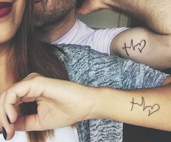 Tatoveringer på to arme for piger, mandlige på hullet, inskriptioner. Foto