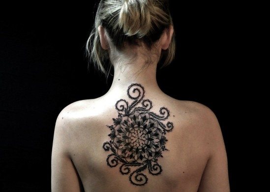 女の子の背中のタトゥー：象形文字、翻訳を伴う碑文、花、点、ルーン文字、惑星、ライン。美しいデザイン