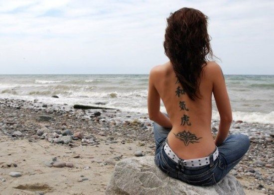 Tatuagens na coluna (costas) em raparigas: hieróglifos, inscrições com tradução, flores, ponto, runas, planetas, linhas. Desenhos bonitos
