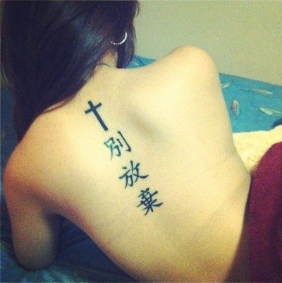 女子の背中のタトゥー：ヒエログリフ、翻訳を伴う碑文、花、点、ルーン文字、惑星、ライン。美しいデザイン