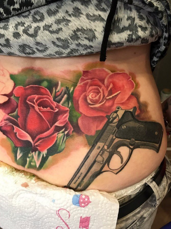Татуировка на рози с пистолет върху тялото на момиче