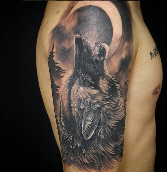 Uivar de lobo na lua - uma tatuagem de um roqueiro no seu ombro