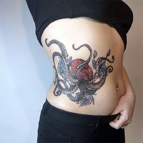 Mulher tatuada com polvo do seu lado