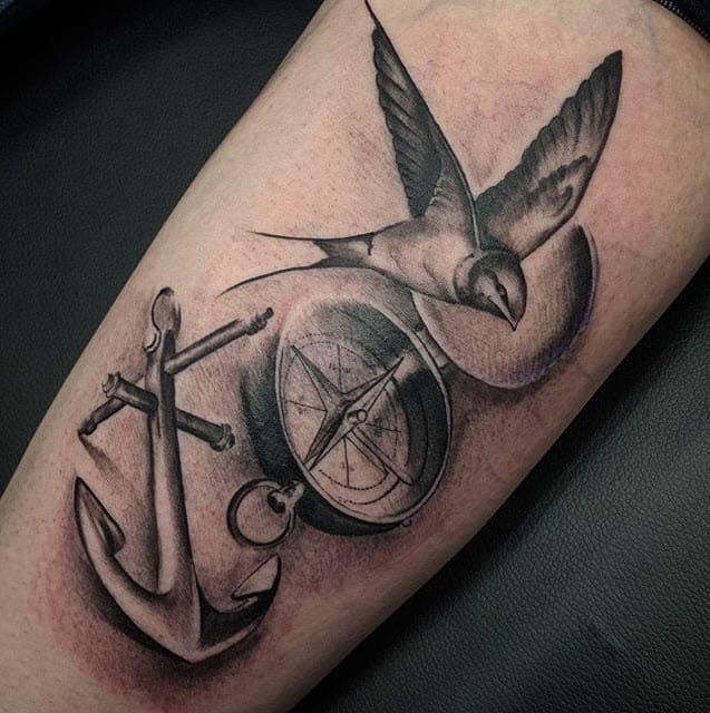 tatuointi, joka tarkoittaa kompassia, jossa on pääskynen ja ankkuri